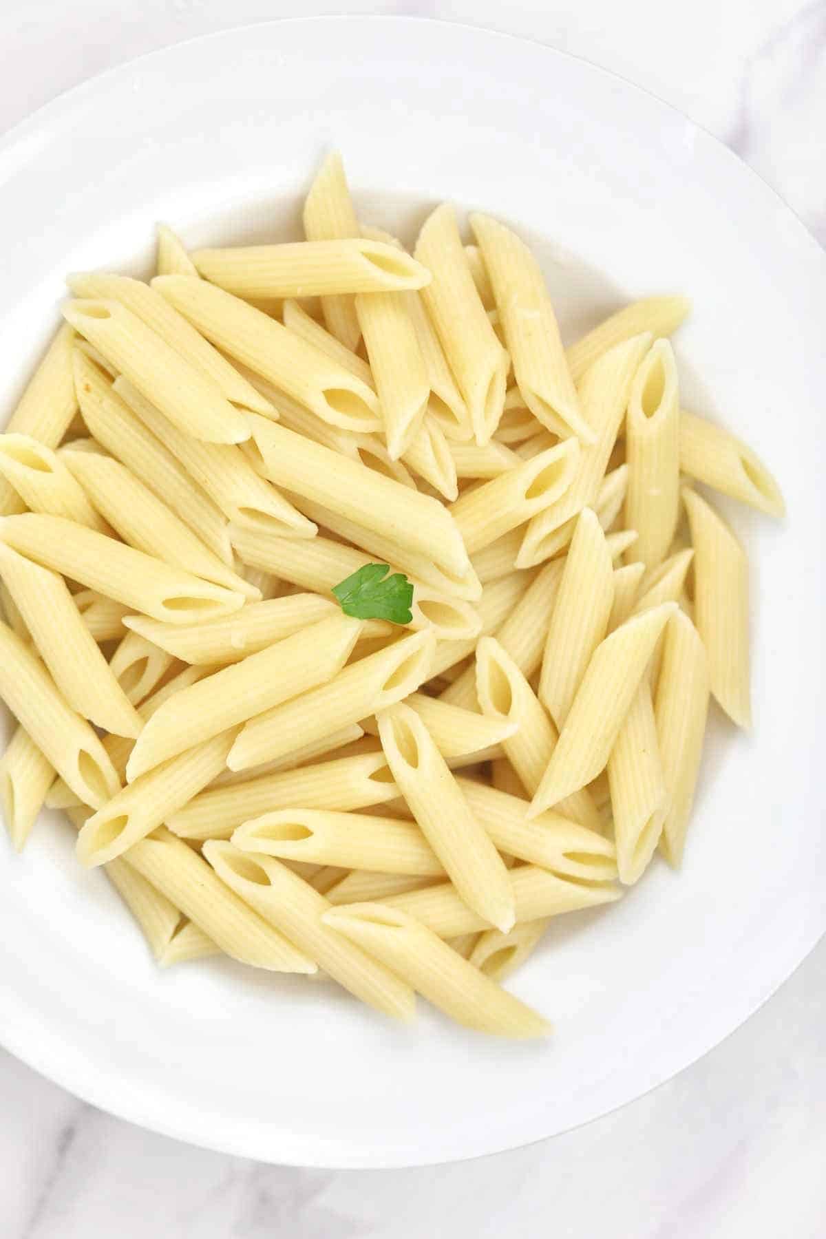 boiled pasta served on a white plate.