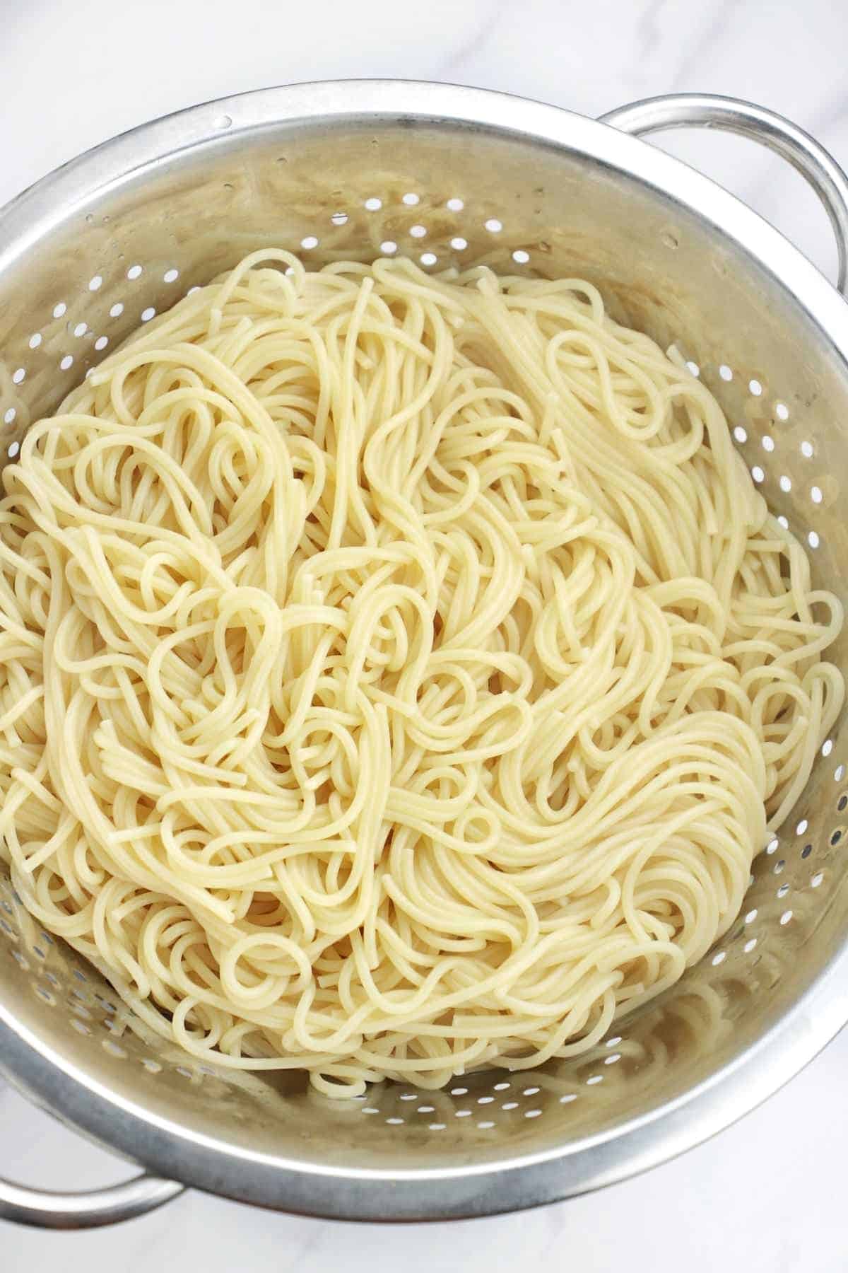 cooked spaghetti noodles in a colander.